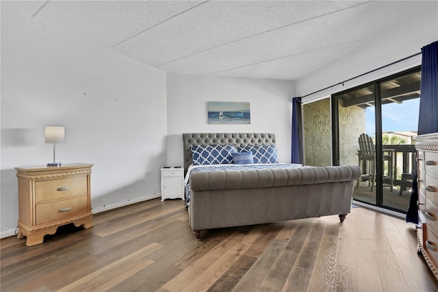 bedroom featuring dark hardwood / wood-style floors, access to exterior, and a textured ceiling