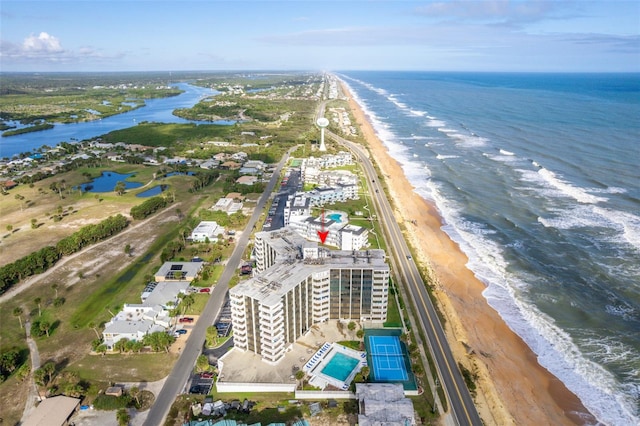 birds eye view of property with a water view and a beach view