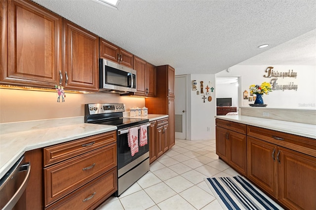 kitchen featuring light tile floors, a textured ceiling, and stainless steel appliances