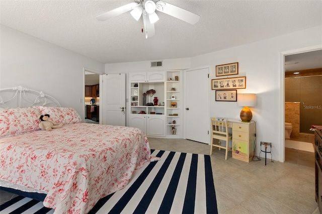 tiled bedroom with ceiling fan and a textured ceiling