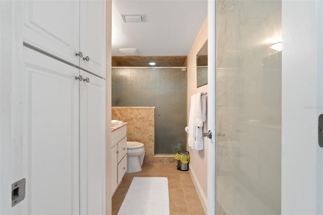 bathroom featuring vanity, tile walls, a shower with door, tile flooring, and toilet