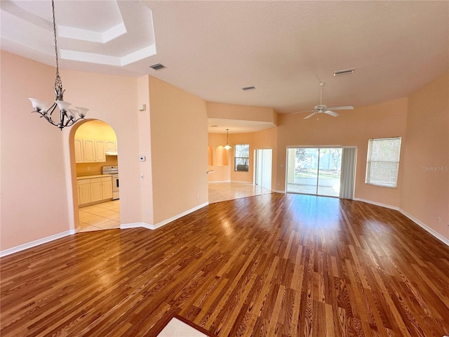 unfurnished living room with light hardwood / wood-style floors and ceiling fan with notable chandelier