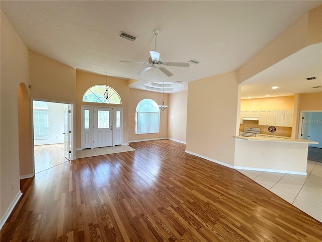 interior space with ceiling fan, lofted ceiling, and light tile floors