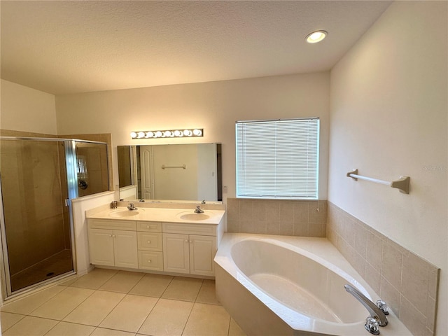 bathroom featuring shower with separate bathtub, a textured ceiling, dual bowl vanity, and tile flooring