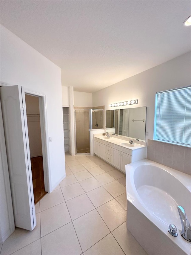 bathroom featuring shower with separate bathtub, double sink vanity, and tile flooring