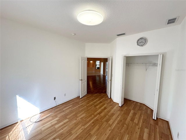 unfurnished bedroom featuring light hardwood / wood-style floors and a closet