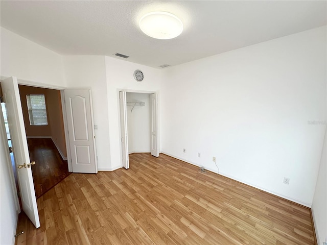 unfurnished bedroom with a closet and light hardwood / wood-style floors