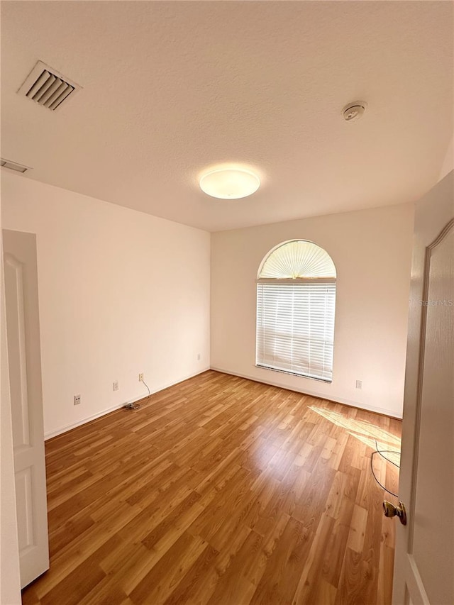 unfurnished room with hardwood / wood-style floors