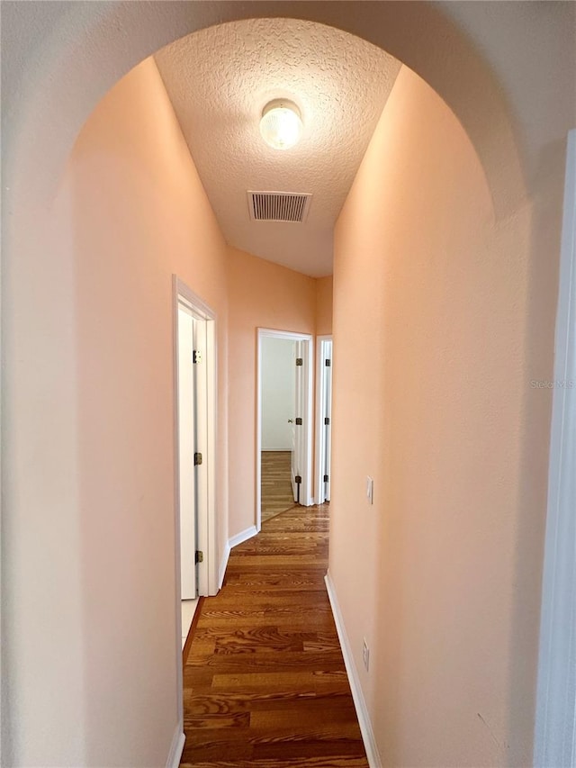 hall featuring dark hardwood / wood-style floors and a textured ceiling