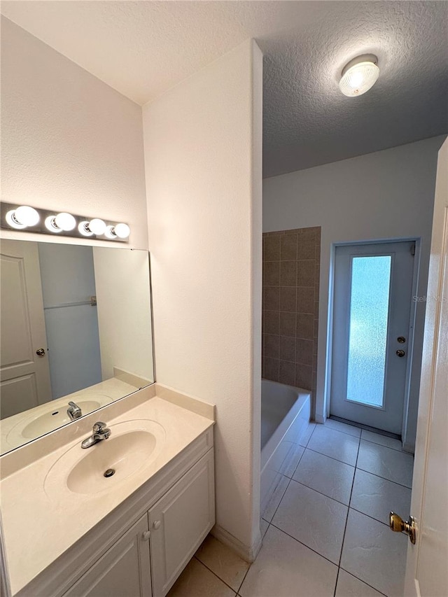 bathroom featuring a textured ceiling, vanity, and tile flooring