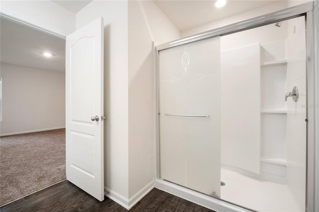 bathroom with hardwood / wood-style floors and an enclosed shower