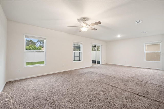 unfurnished room with ceiling fan and carpet