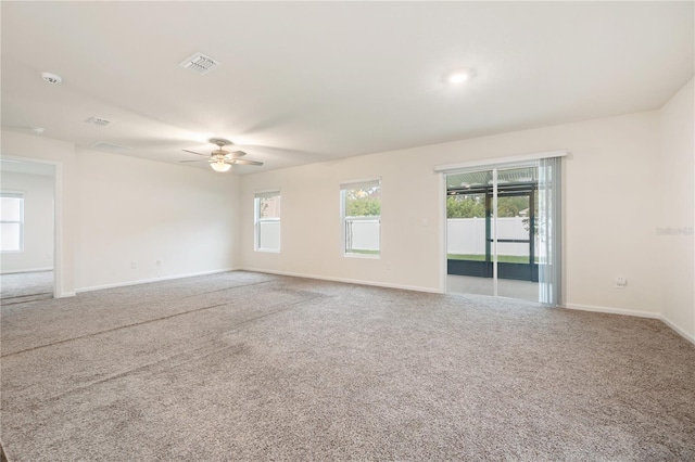 carpeted spare room with ceiling fan and a healthy amount of sunlight