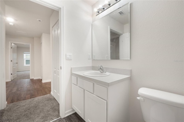 bathroom with vanity, hardwood / wood-style floors, and toilet