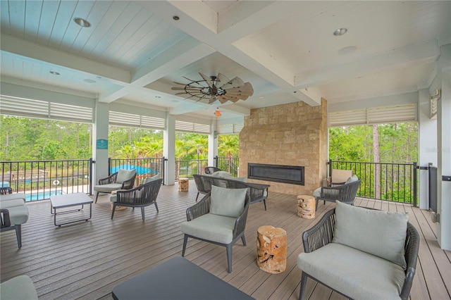 deck featuring ceiling fan, a swimming pool, and an outdoor living space with a fireplace