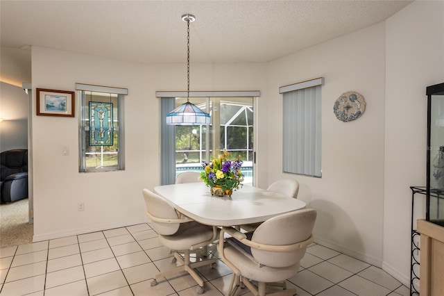 dining room featuring light tile floors and a textured ceiling