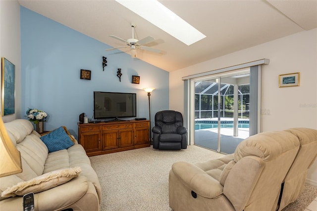 carpeted living room featuring vaulted ceiling with skylight and ceiling fan