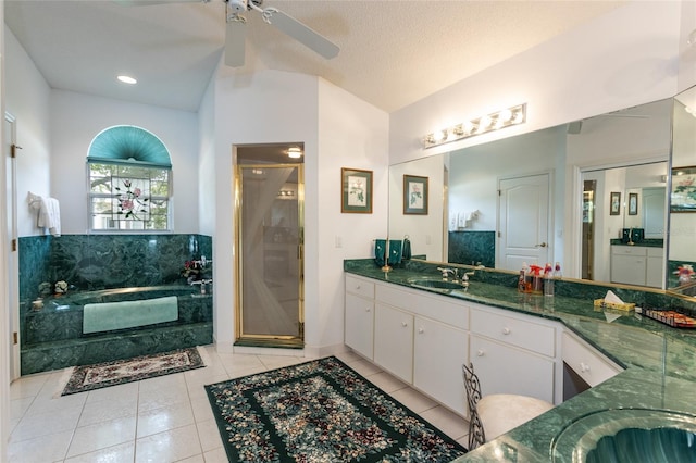 bathroom with ceiling fan, a textured ceiling, tile flooring, plus walk in shower, and vanity