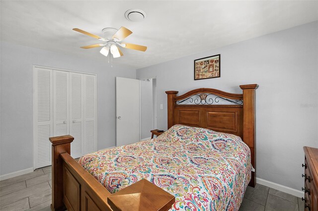 bedroom with ceiling fan, light tile patterned floors, and a closet