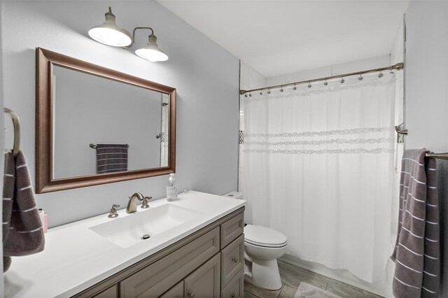 bathroom with toilet, vanity, and a shower with curtain