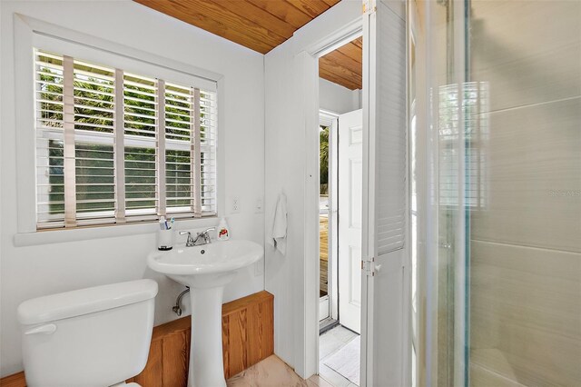 bathroom featuring toilet, a shower with shower door, and wooden ceiling