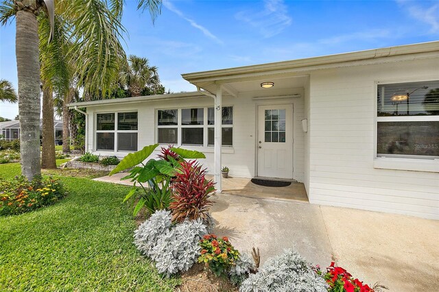 entrance to property with a lawn