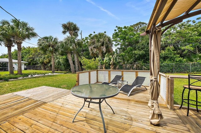 wooden terrace featuring a yard