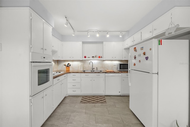 kitchen with backsplash, sink, white appliances, and white cabinets