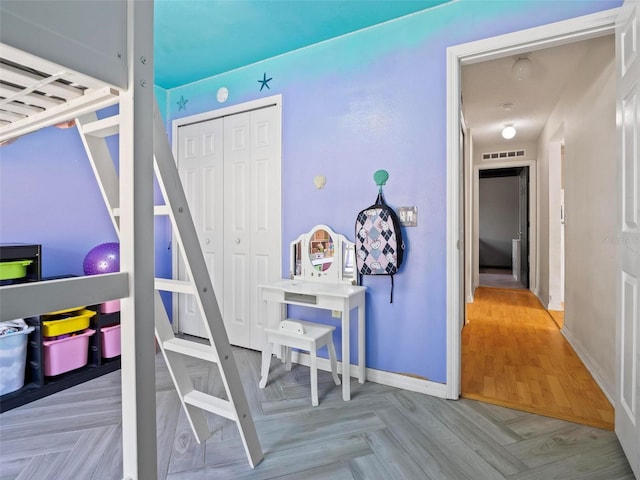 bedroom featuring light parquet floors and a closet