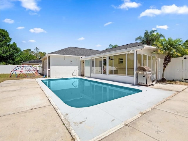 view of swimming pool with a patio, grilling area, and a sunroom