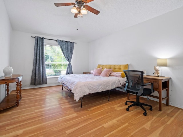 bedroom featuring a textured ceiling, ceiling fan, and light hardwood / wood-style floors