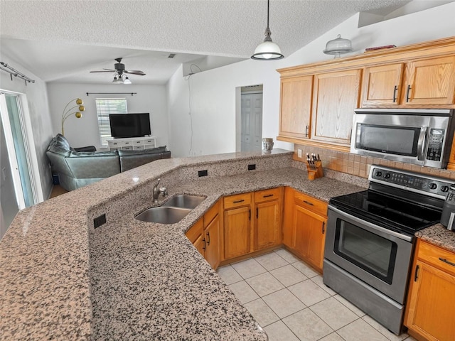 kitchen with a textured ceiling, appliances with stainless steel finishes, sink, kitchen peninsula, and light tile patterned floors