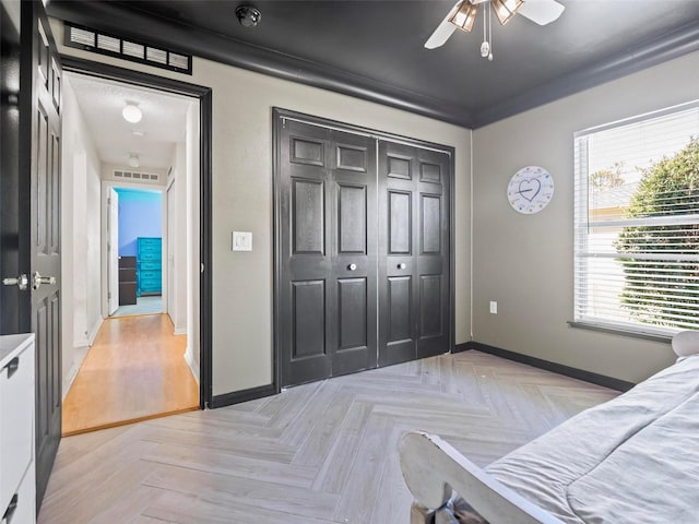 bedroom featuring ceiling fan, light parquet flooring, and a closet