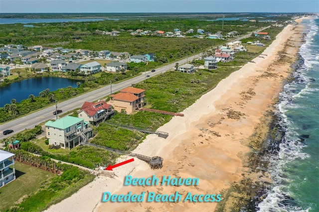 birds eye view of property featuring a beach view and a water view