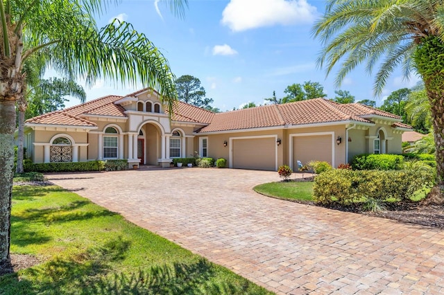 mediterranean / spanish-style house with a garage and a front lawn