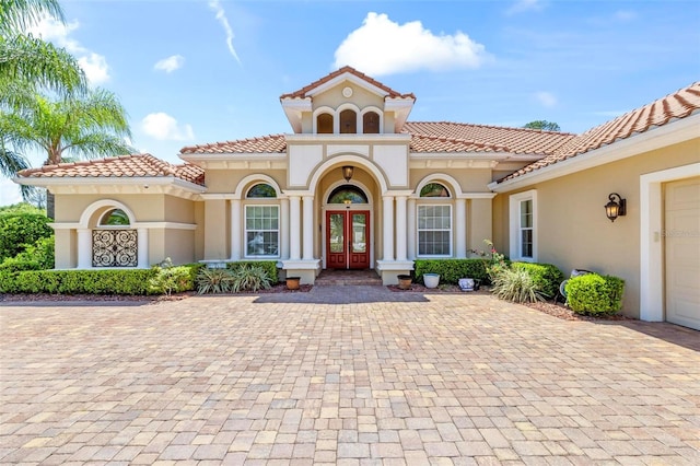 mediterranean / spanish-style house with a garage and french doors