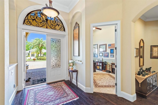 foyer entrance with crown molding, dark hardwood / wood-style flooring, and ceiling fan