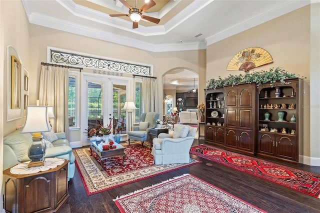 living room with crown molding, ceiling fan, and dark hardwood / wood-style floors