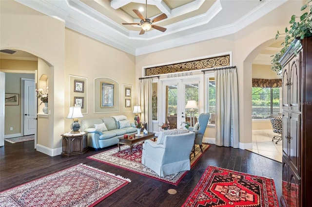 living room with french doors, dark hardwood / wood-style floors, ornamental molding, coffered ceiling, and ceiling fan