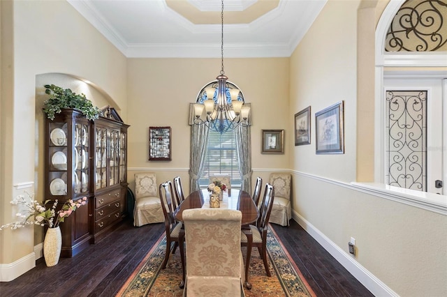 dining room with dark hardwood / wood-style floors, a raised ceiling, crown molding, and a chandelier