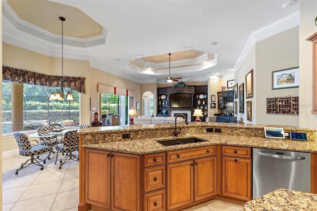 kitchen featuring sink, decorative light fixtures, stainless steel dishwasher, and light stone counters