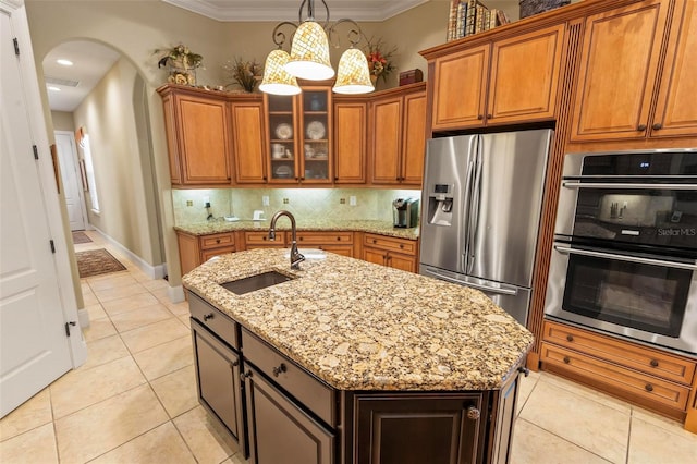 kitchen featuring a kitchen island with sink, stainless steel appliances, light tile floors, sink, and tasteful backsplash