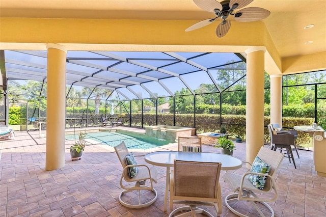 view of patio with ceiling fan and glass enclosure