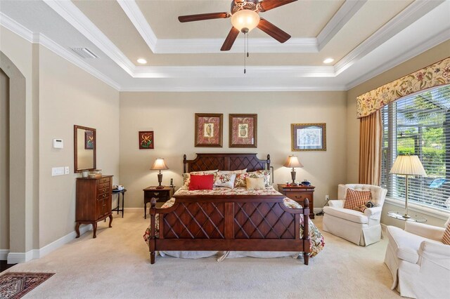 bedroom featuring ornamental molding, ceiling fan, a tray ceiling, and light carpet