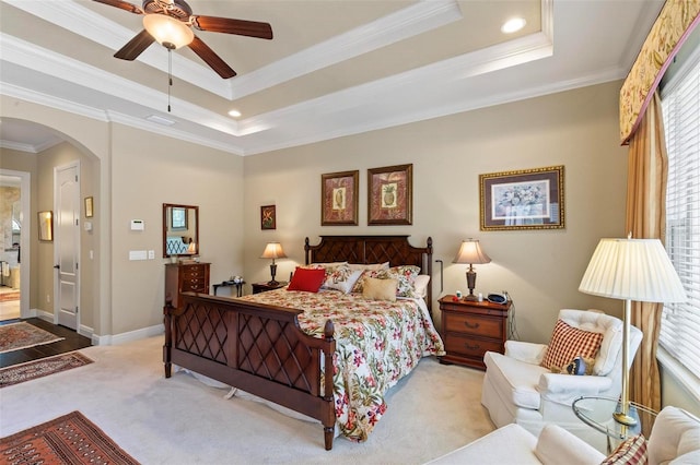 bedroom with a raised ceiling, ceiling fan, light carpet, and ornamental molding