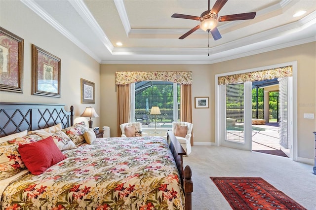 bedroom with a raised ceiling, ceiling fan, light carpet, and multiple windows