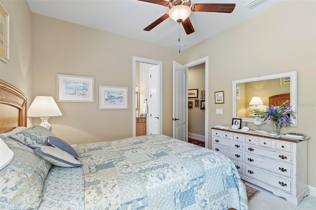 bedroom featuring ceiling fan, light carpet, and connected bathroom