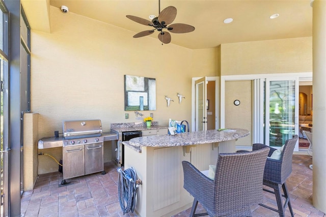 view of patio with area for grilling and ceiling fan