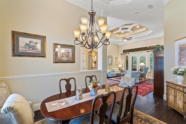 dining area featuring crown molding, dark hardwood / wood-style floors, a high ceiling, a notable chandelier, and a raised ceiling