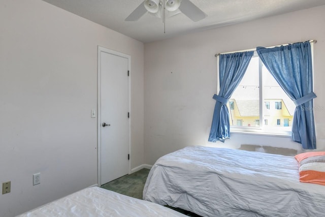 bedroom with ceiling fan and dark colored carpet